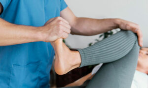 Imagen Hombre, realizando sesión de fisioterapia para mejorar la movilidad de una pierna en clínica Oropesa